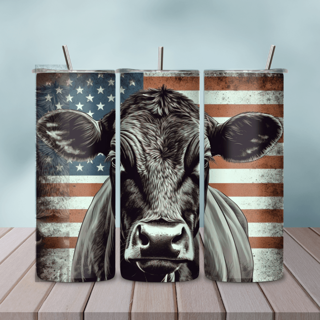 Patriotic Angus Cow American Flag Skinny Tumbler set on a wooden table, perfect for rancher gifts and patriotic celebrations.