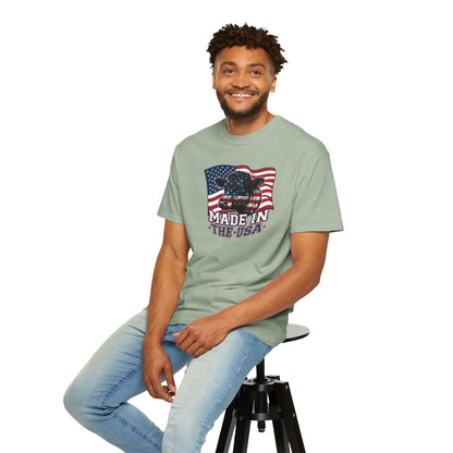 Rancher T-Shirt featuring a patriotic design with 'Made in the USA' text, worn by a man sitting on a stool.