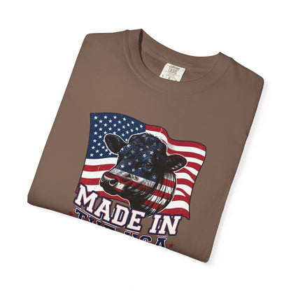 Rancher T-Shirt featuring a patriotic cow graphic against an American flag background, representing American pride.