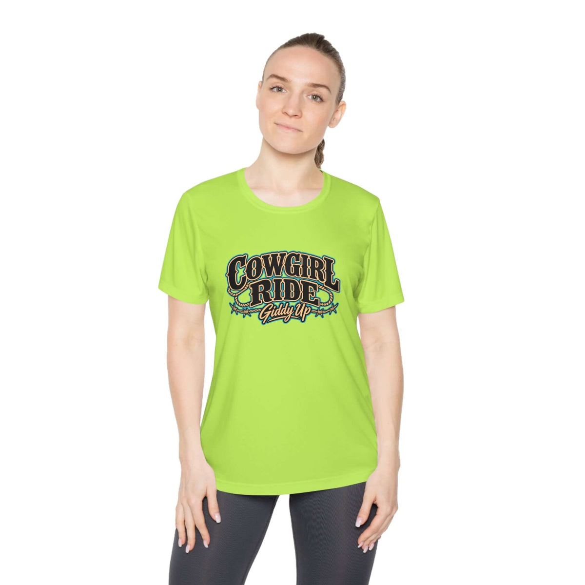 Cowgirl Ride Giddy Up Ladies Tee in vibrant green with vintage lettering and rustic accents worn by a model.
