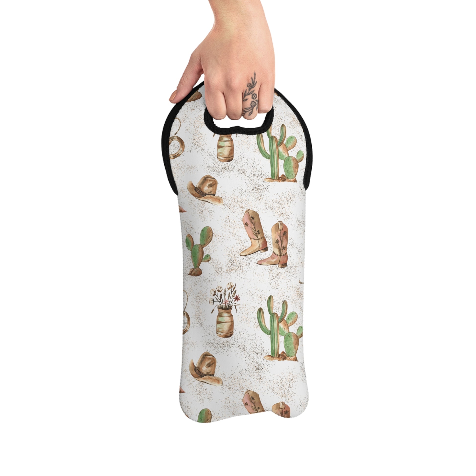 A hand holding a Cowboy Wine Bag with a rustic design featuring boots and cacti.