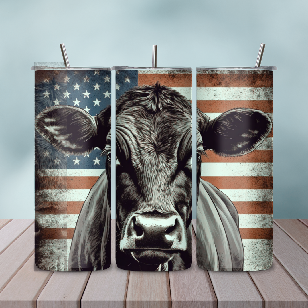 Patriotic Angus Cow American Flag Skinny Tumbler set on a wooden table, perfect for rancher gifts and patriotic celebrations.
