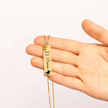 Chase Your Dreams Vertical Bar Necklace held in hand, featuring customizable quote and birthstone detail.